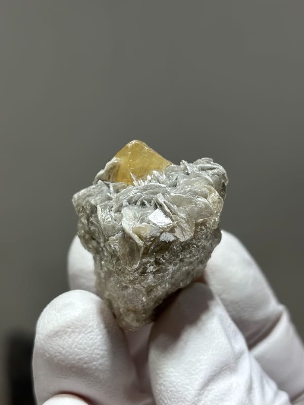Honey scheelite crystal on mica block from Xuebaoding, Sichuan, China, close-up of the crystal faces