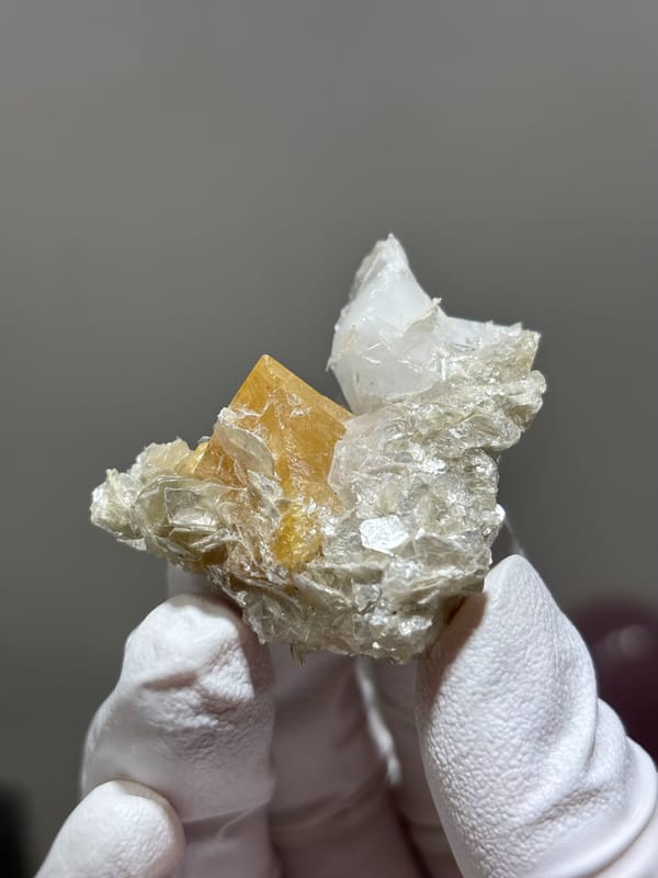 Honey scheelite with clear quartz point and mica from Xuebaoding, Sichuan, China, close-up of the crystal faces