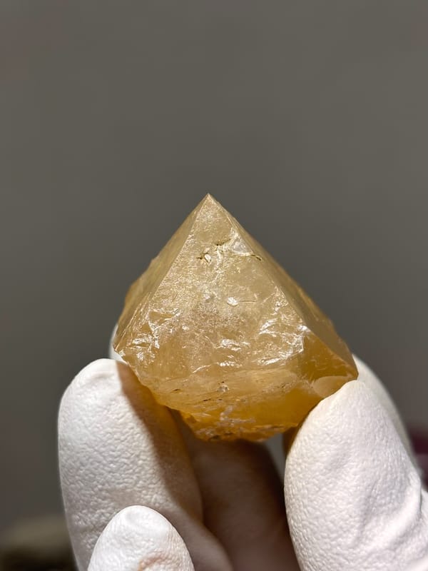 Honey scheelite crystal with mica fleck from Xuebaoding, Sichuan, China, close-up of the crystal faces