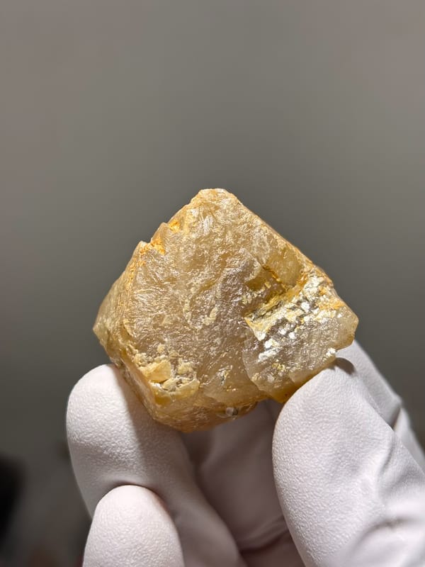 Honey-orange scheelite with mica on its faces from Xuebaoding, Sichuan, China, close-up of the crystal faces