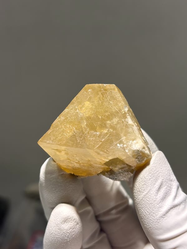 Honey-orange scheelite with complete tip from Xuebaoding, Sichuan, China, close-up of the crystal faces