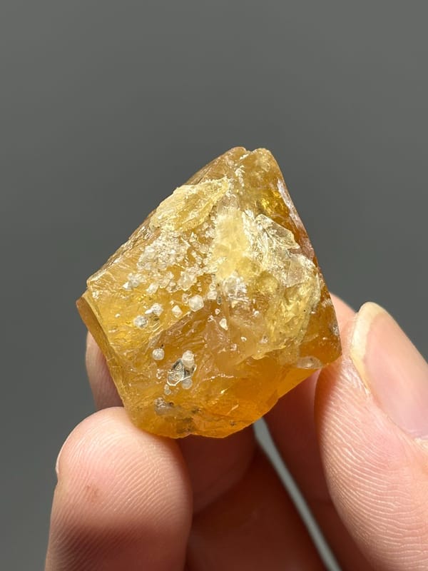 Orange scheelite crystal with white calcite from Xuebaoding, Sichuan, China, close-up of the crystal faces