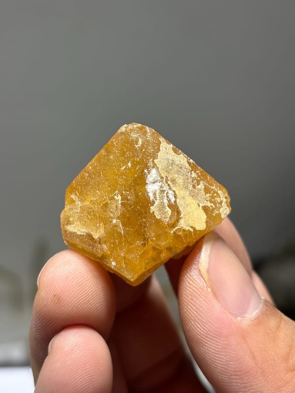 Orange scheelite crystal with white calcite from Xuebaoding, Sichuan, China, reverse side