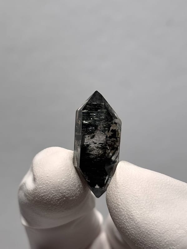 Tiny black double-terminated quartz from Yunnan, China, close-up of the crystal faces