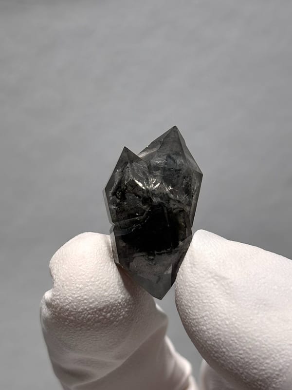 Stout black double-terminated quartz with clear cap from Yunnan, China, detail of the matrix contact