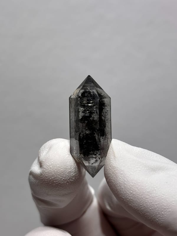 Black double-terminated quartz with clear rim from Yunnan, China, detail of the matrix contact