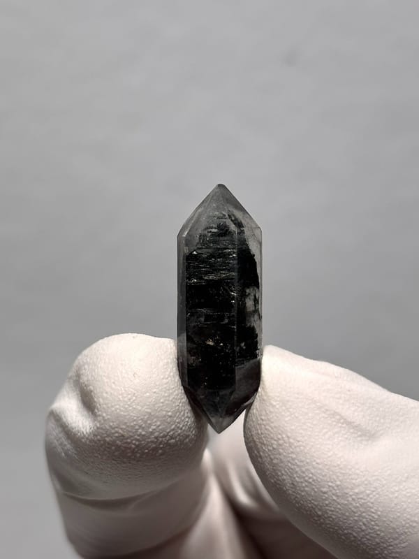 Tiny black double-terminated quartz with clear rim from Yunnan, China, close-up of the crystal faces