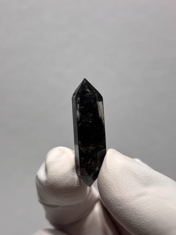 Tiny black double-terminated quartz from Yunnan, China, close-up of the crystal faces