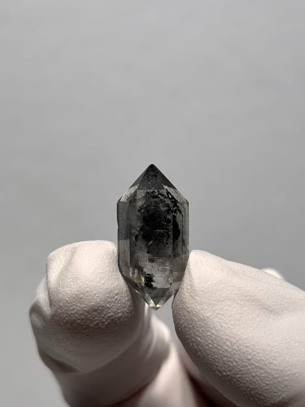 Tiny black sugar-core double-terminated quartz from Yunnan, China, close-up of the crystal faces