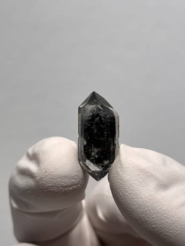 Tiny black sugar-core double-terminated quartz from Yunnan, China, close-up of the crystal faces