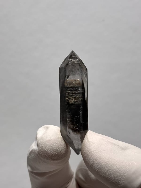 Slender black sugar-core double-terminated quartz from Yunnan, China, close-up of the crystal faces