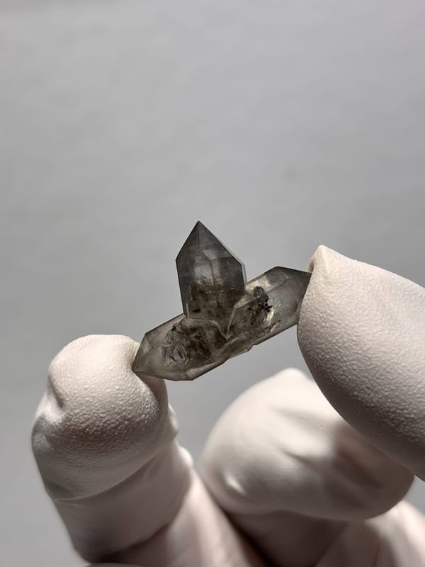 Tiny black-flecked quartz pair with crossing crystal from Yunnan, China, second angle