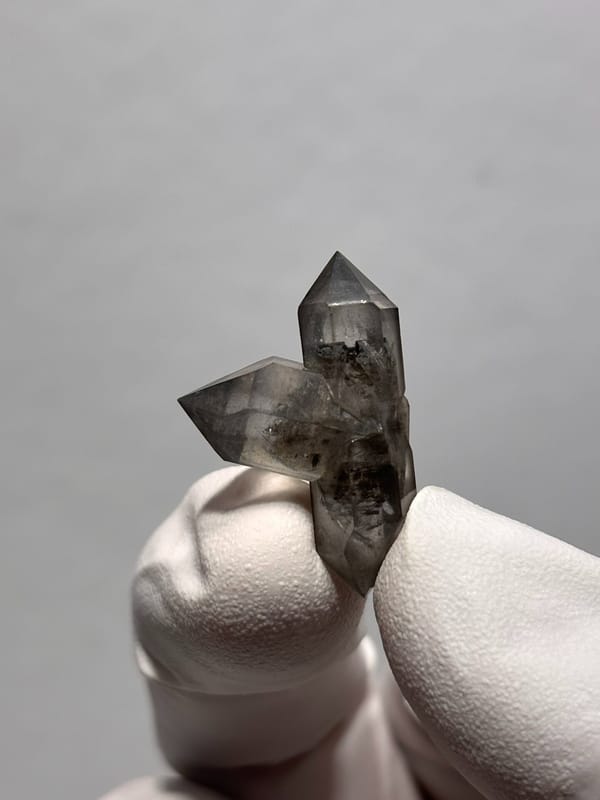 Tiny black-flecked quartz pair with crossing crystal from Yunnan, China, reverse side