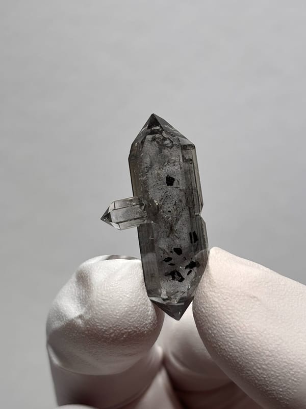 Black-flecked double-terminated quartz with side crystal from Yunnan, China, close-up of the crystal faces
