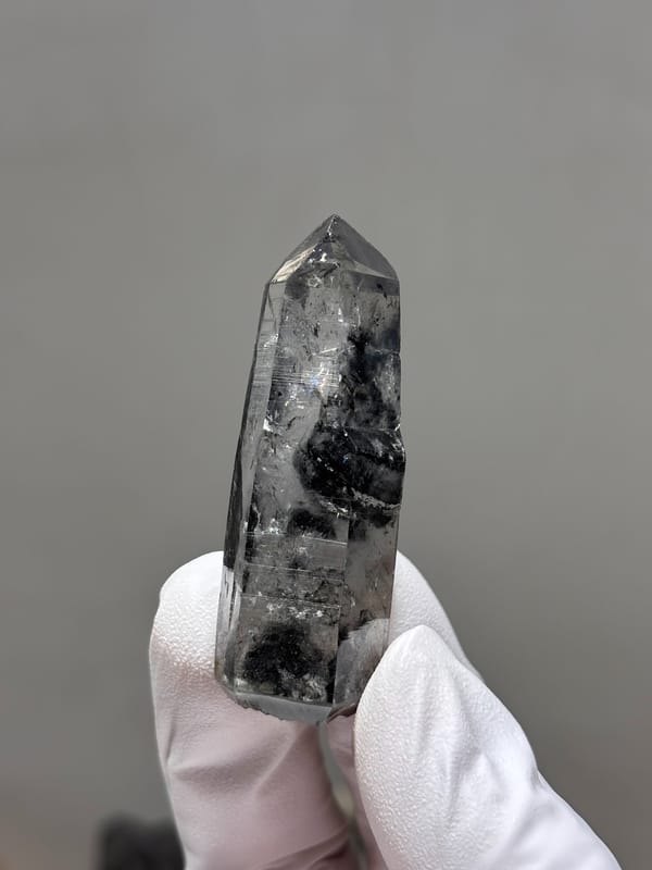 Black-included quartz point with rainbow flash from Jinkouhe, Sichuan, China, close-up of the crystal faces