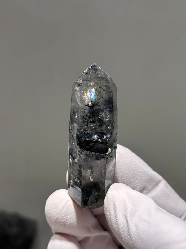 Black-included quartz point with rainbow flash from Jinkouhe, Sichuan, China, reverse side
