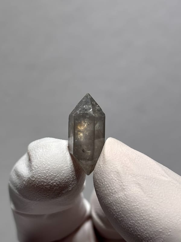 Tiny burst-crystal sketch-pattern quartz from Yunnan, China, held in gloved hand