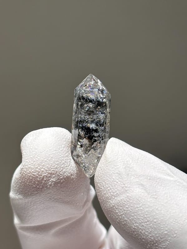Tiny burst-crystal double-terminated quartz from Yunnan, China, held in gloved hand