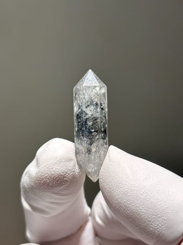 Tiny burst-crystal double-terminated quartz from Yunnan, China, held in gloved hand