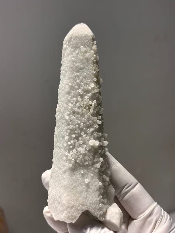 White candle quartz tower from Inner Mongolia, China, held in gloved hand