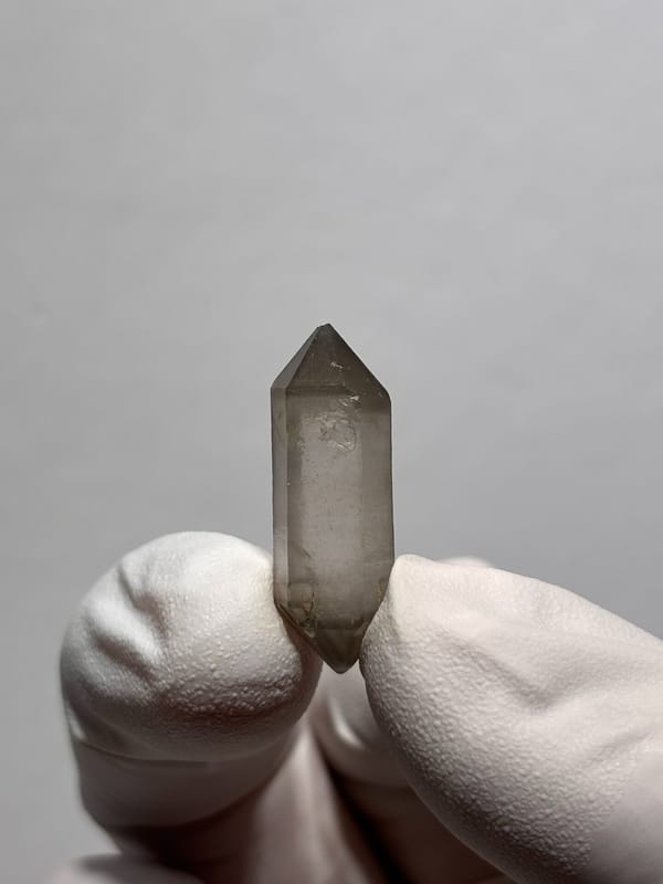 Tiny smoky capped double-terminated quartz from Yunnan, China, close-up of the crystal faces