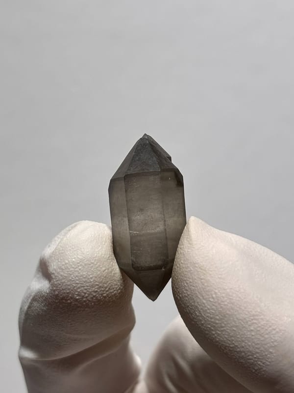 Tiny smoky capped double-terminated quartz from Yunnan, China, close-up of the crystal faces