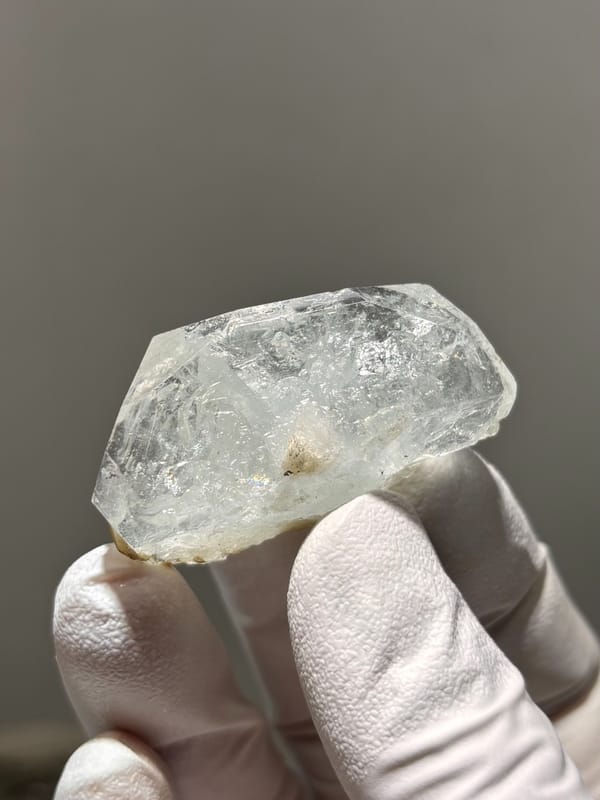 Clear aquamarine tablet with jamesonite needles inside from Xuebaoding, Sichuan, China, close-up of the crystal faces