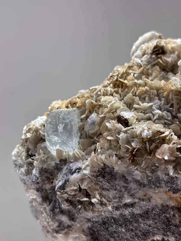 Dark mica block with aquamarine, cassiterite and scheelite from Xuebaoding, Sichuan, China, reverse side