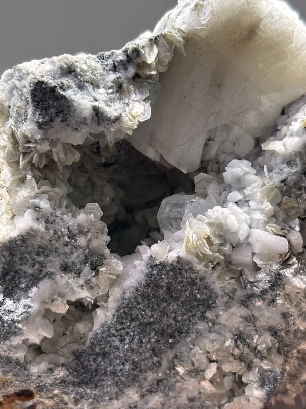 Dark mica block with aquamarine, cassiterite and scheelite from Xuebaoding, Sichuan, China, side view