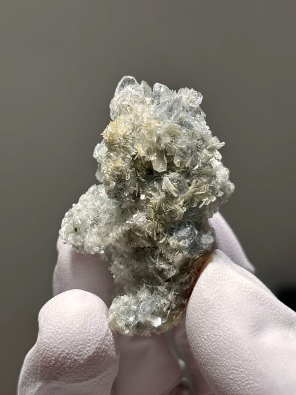 Small aquamarine crystals on pale mica cluster from Xuebaoding, Sichuan, China, close-up of the crystal faces