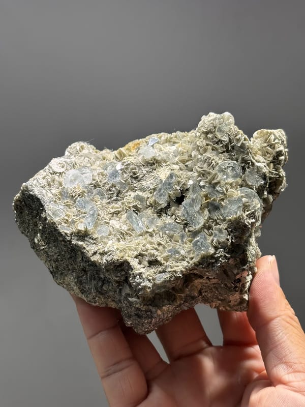 Mica plate with pale aquamarine from Xuebaoding, Sichuan, China, held in hand