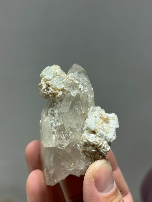 Quartz point over white feldspar with aquamarine and mica from Xuebaoding, Sichuan, China, second angle
