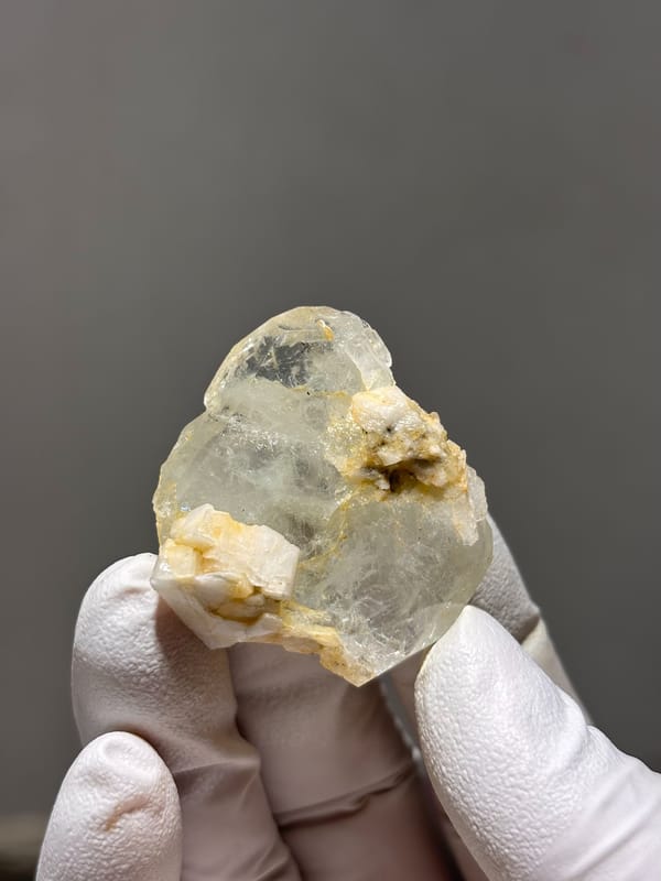 Clear aquamarine with golden feldspar patches from Xuebaoding, Sichuan, China, close-up of the crystal faces