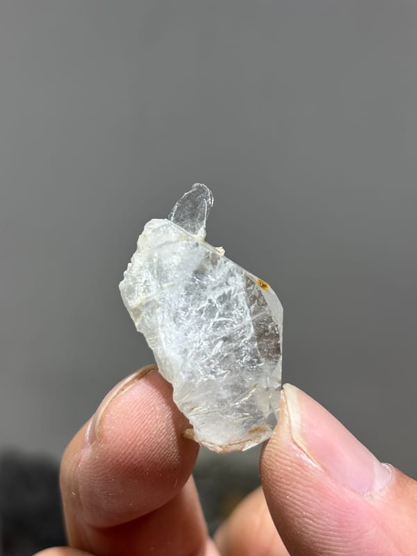 Tiny clear aquamarine sliver with mica from Xuebaoding, Sichuan, China, close-up of the crystal faces