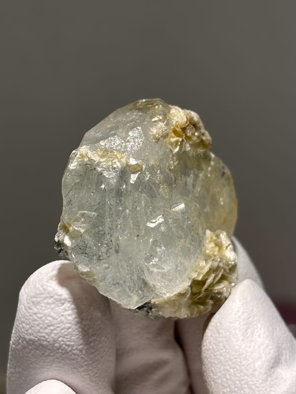 Clear aquamarine tablet with mica and jamesonite from Xuebaoding, Sichuan, China, close-up of the crystal faces
