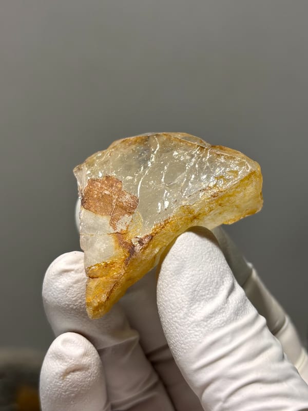 Clear aquamarine tablet with golden patch from Xuebaoding, Sichuan, China, close-up of the crystal faces