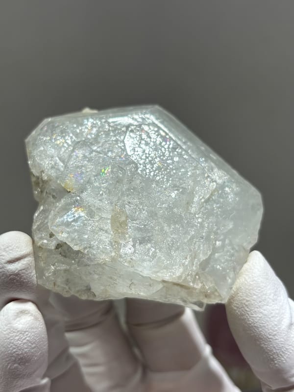 Complete pale aquamarine crystal with frosted faces from Xuebaoding, Sichuan, China, held in gloved hand