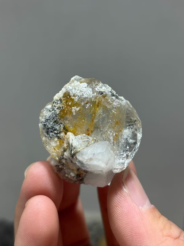 Yellow gel-flower aquamarine with mica and feldspar from Sichuan, China, held in hand