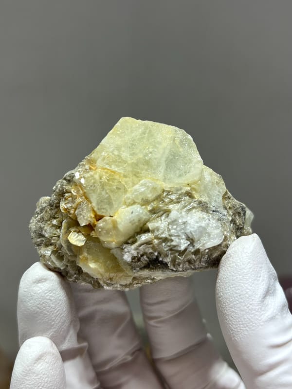 Glassy aquamarine group with golden mica from Xuebaoding, Sichuan, China, close-up of the crystal faces