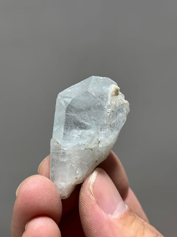 Glassy pale blue aquamarine floater tablet from Xuebaoding, Sichuan, China, close-up of the crystal faces