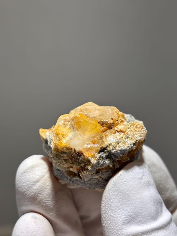 Golden-stained aquamarine on dark mica from Xuebaoding, Sichuan, China, reverse side