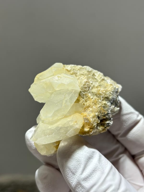 Near-colourless aquamarine cluster on golden mica from Xuebaoding, Sichuan, China, close-up of the crystal faces