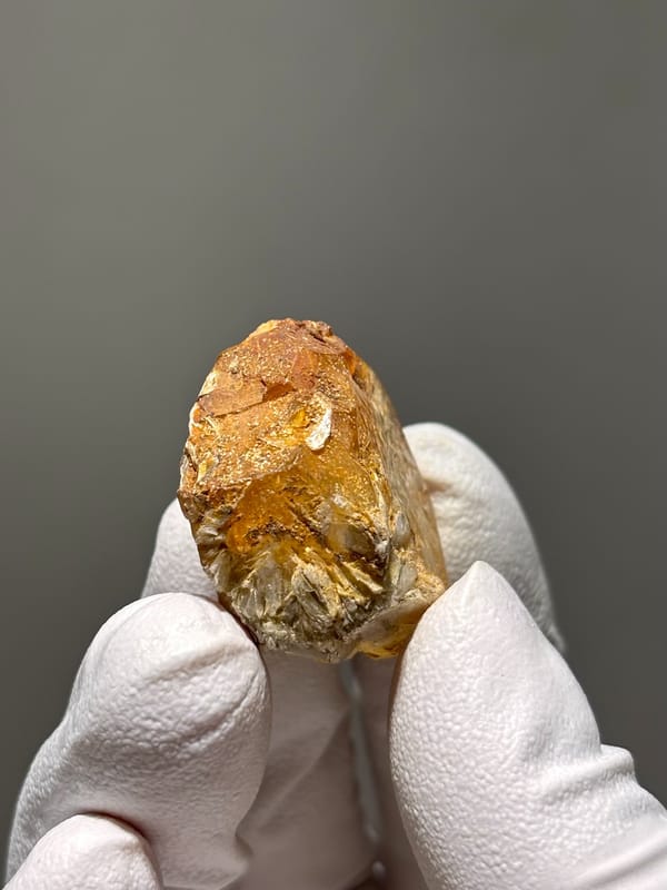 Orange-stained aquamarine tablet from Xuebaoding, Sichuan, China, close-up of the crystal faces