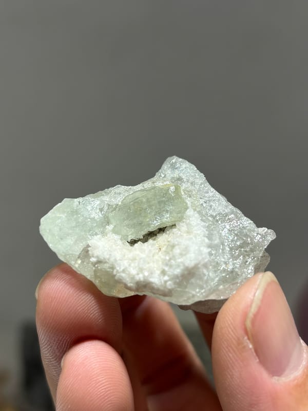 Pale aquamarine with white calcite in pocket from Xuebaoding, Sichuan, China, close-up of the crystal faces