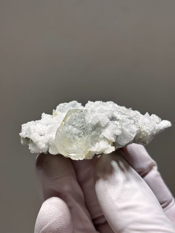 Pale aquamarine crystal on white feldspar from Xuebaoding, Sichuan, China, close-up of the crystal faces