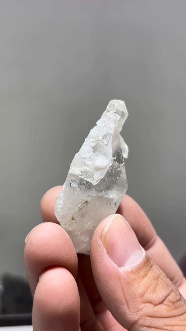 Narrow side of the etched quartz floater, showing attached crystal tips and its free-growing base
