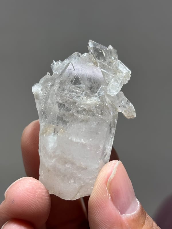 Multi-crystal etched quartz floater from Xuebaoding, Sichuan, China, held in hand