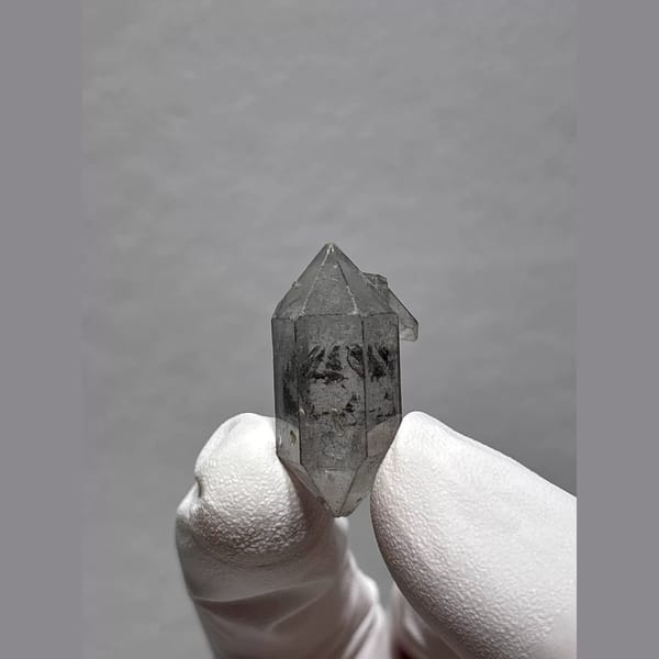 Clear double-terminated Yunnan quartz with dark inclusions — alternate view