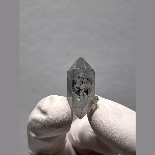 Clear double-terminated Yunnan quartz with dark inclusions — alternate view