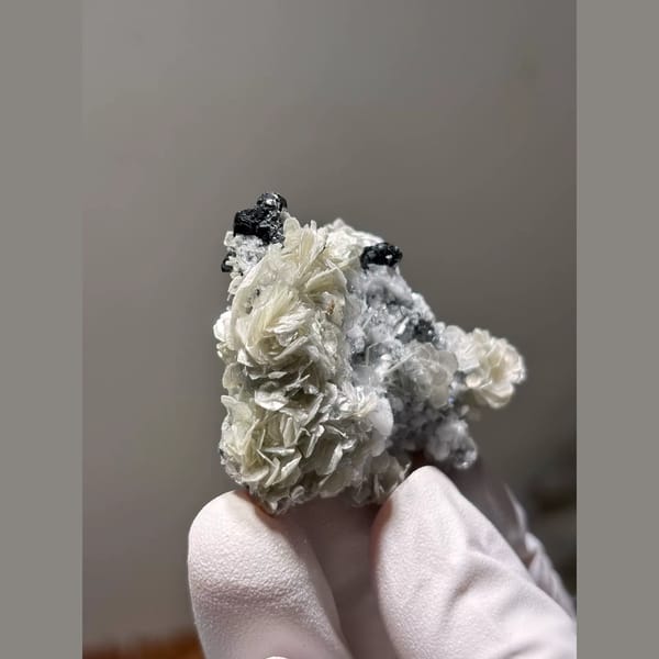 Black cassiterite with mica and feldspar from Xuebaoding, Sichuan — alternate view